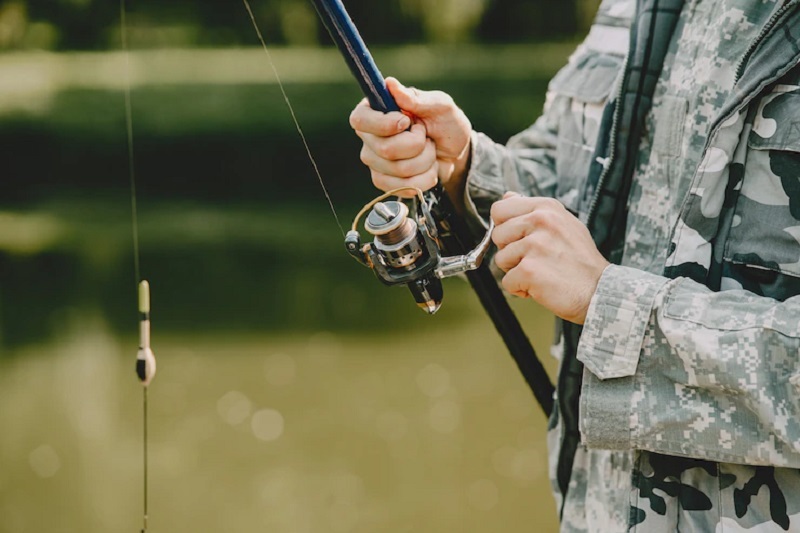 man fishing and holds the angling rod 1157 38057