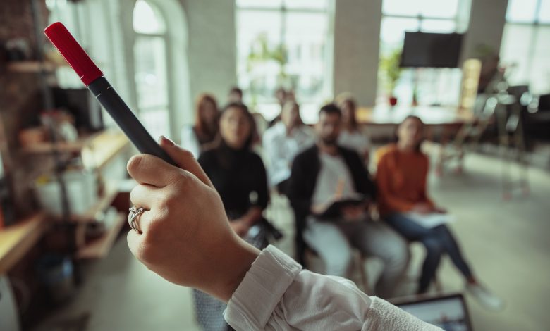 female muslim speaker giving presentation hall workshop audience conference hall close up pointing hand with marker conference event training education diversity inclusive concept 1