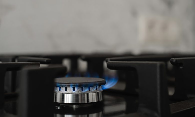 modern kitchen stove natural gas burns with blue flame household gas consumption close up selective focus