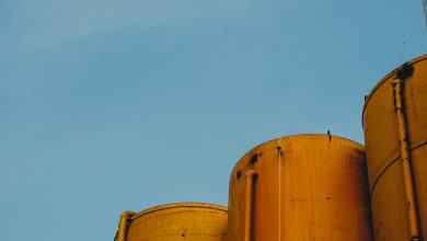 vertical shot four yellow metallic silos with blue sky