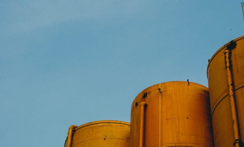 vertical shot four yellow metallic silos with blue sky